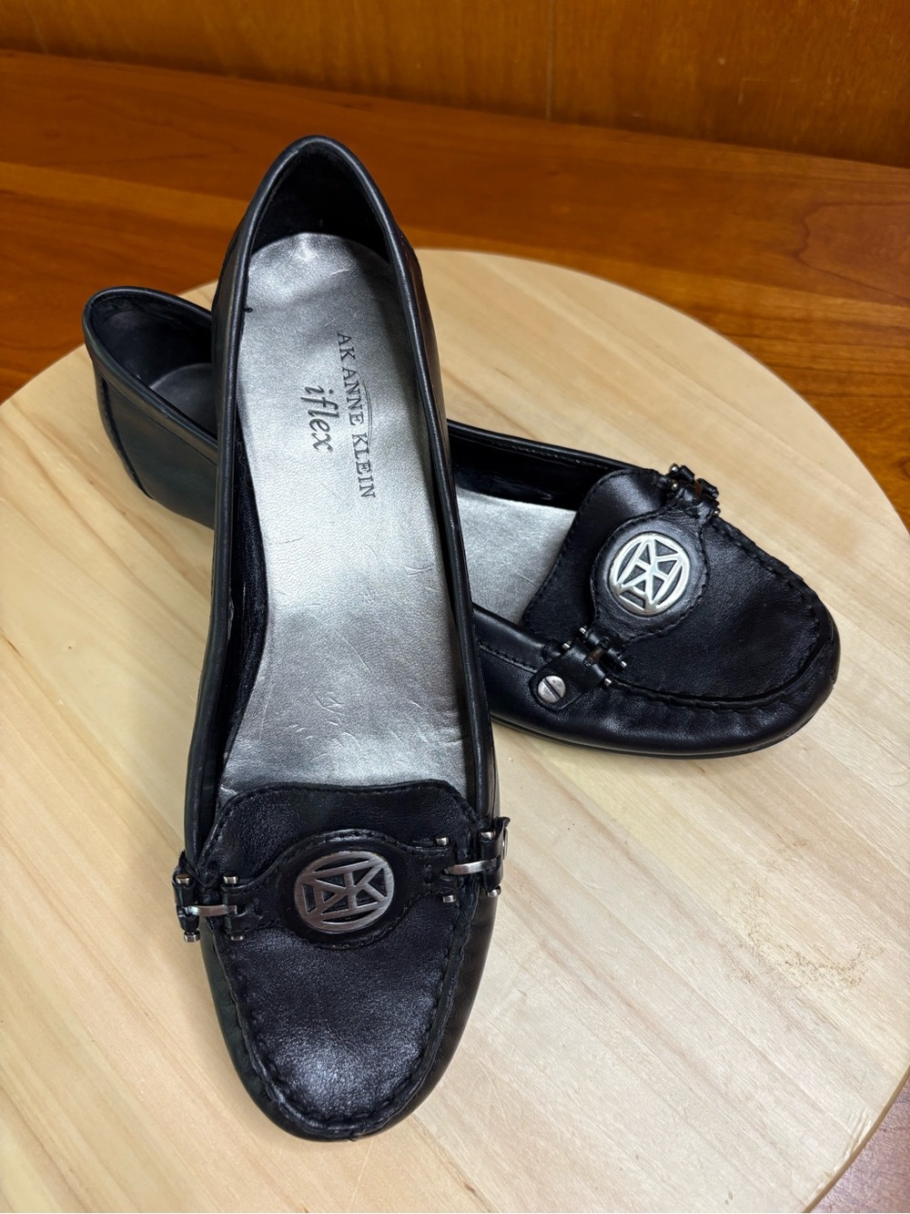 black Anne Klein iFlex NEWLAN loafers feature a silver logo accent on the top.
